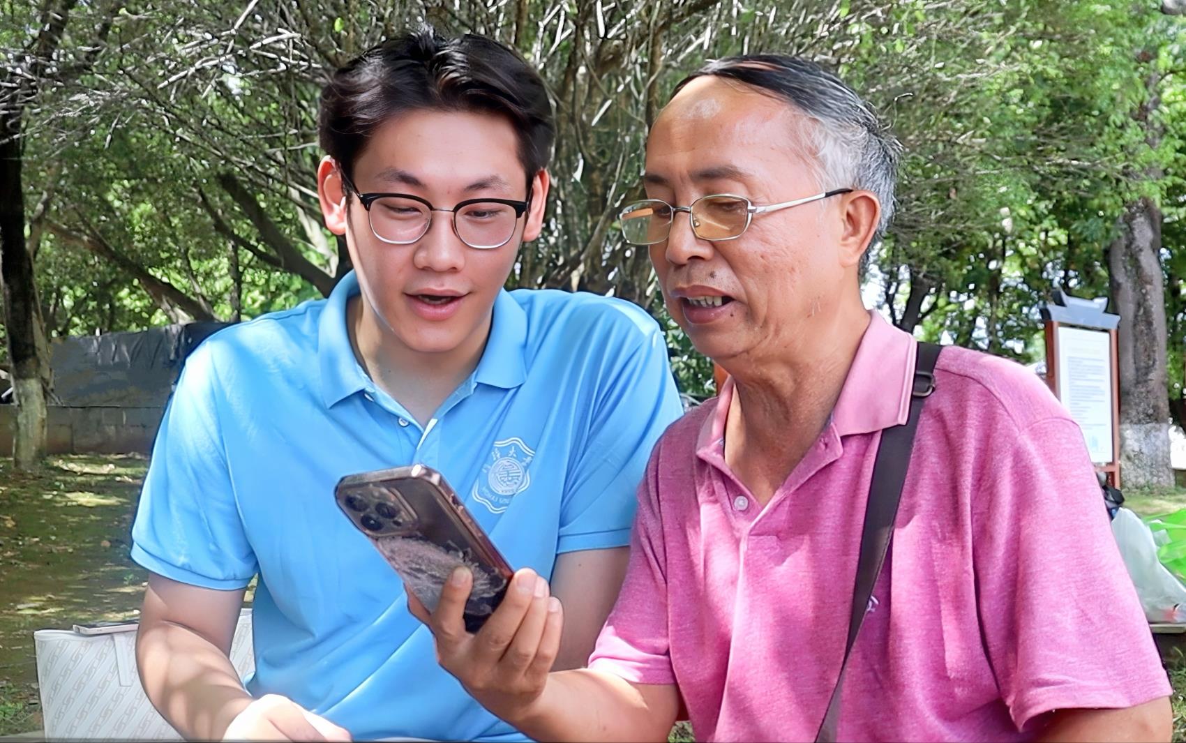 圖為實(shí)踐團(tuán)成員與當(dāng)?shù)乩先艘黄饘W(xué)習(xí)誦讀古詩